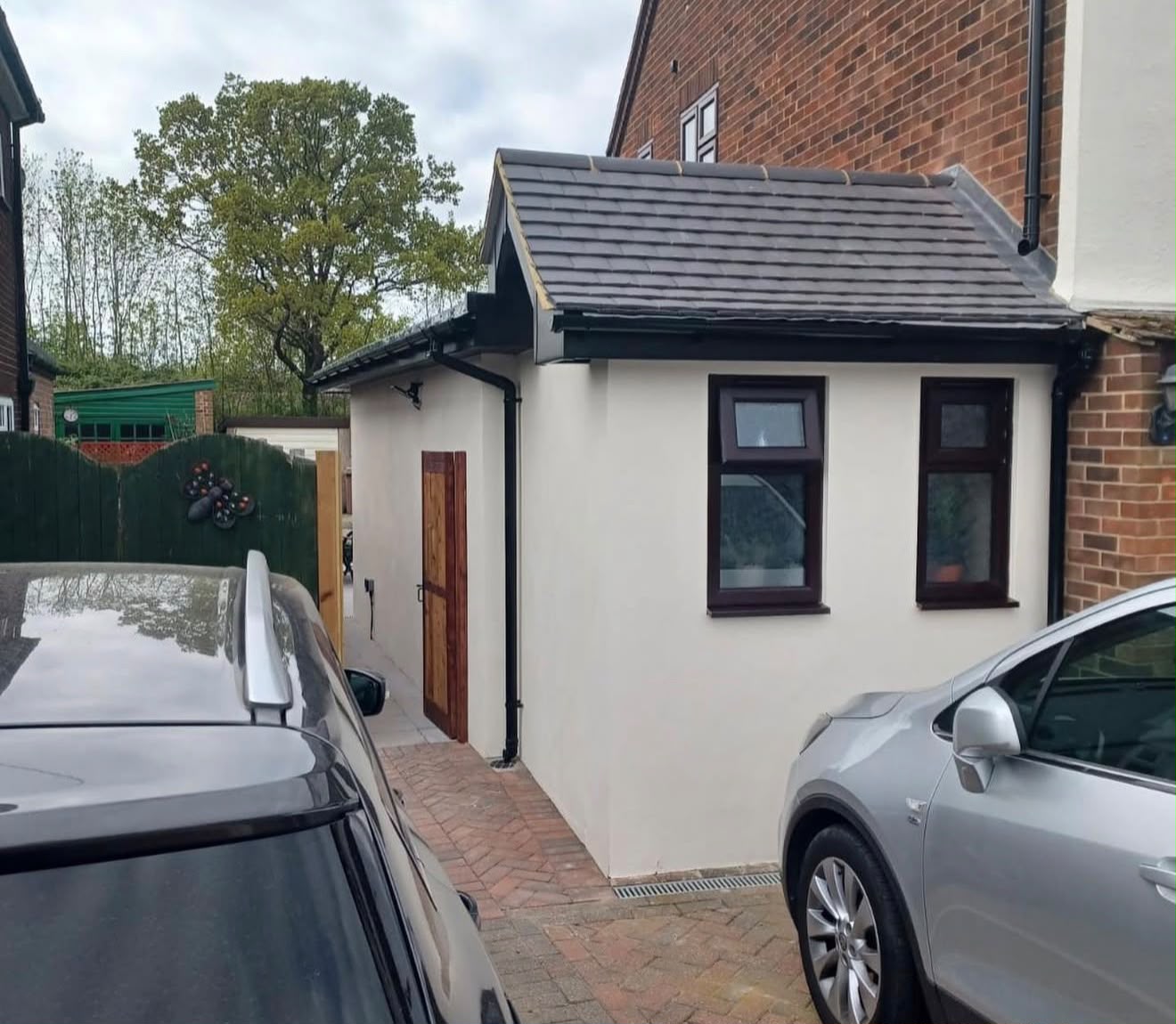 Single-storey side extension with tiled pitched roof and rendered walls